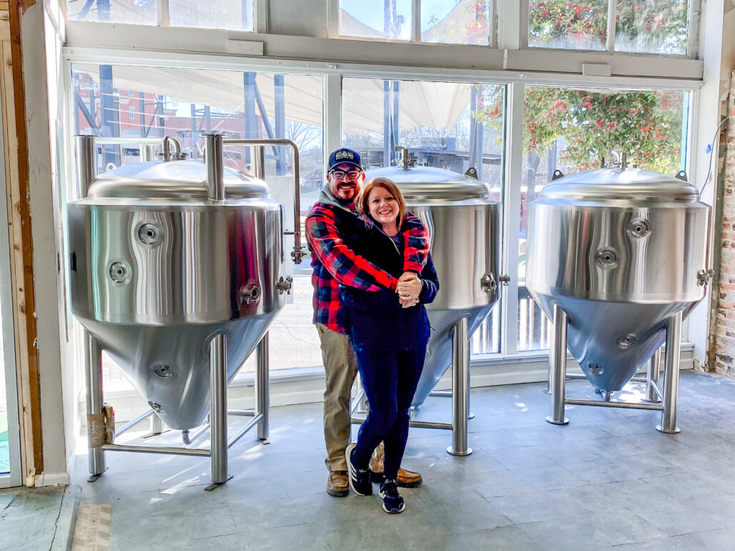 Alex and Tori (owners) standing in Local Ties with newly purchased brewery equipment.